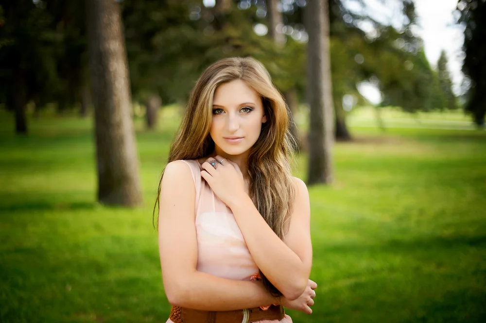 Senior portrait — Ashley against a teal wall